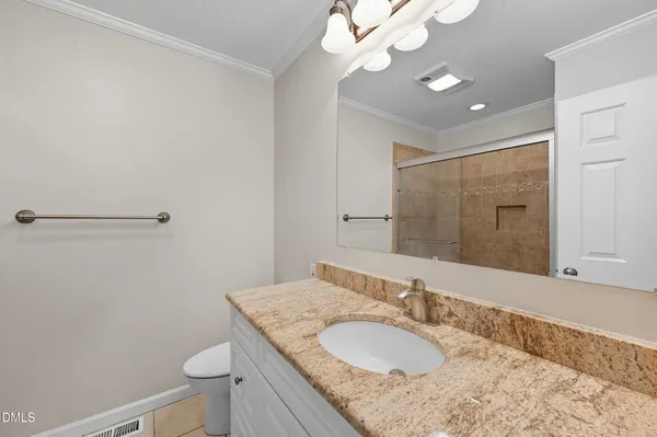 a bathroom with a granite countertop sink a toilet and a mirror