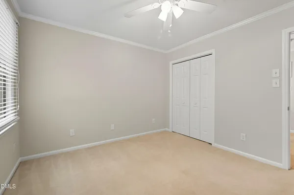 an empty room with a chandelier fan