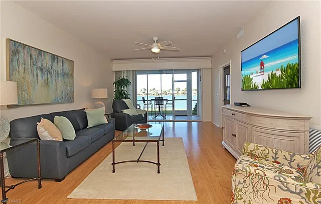 a living room with furniture a flat screen tv and a floor to ceiling window