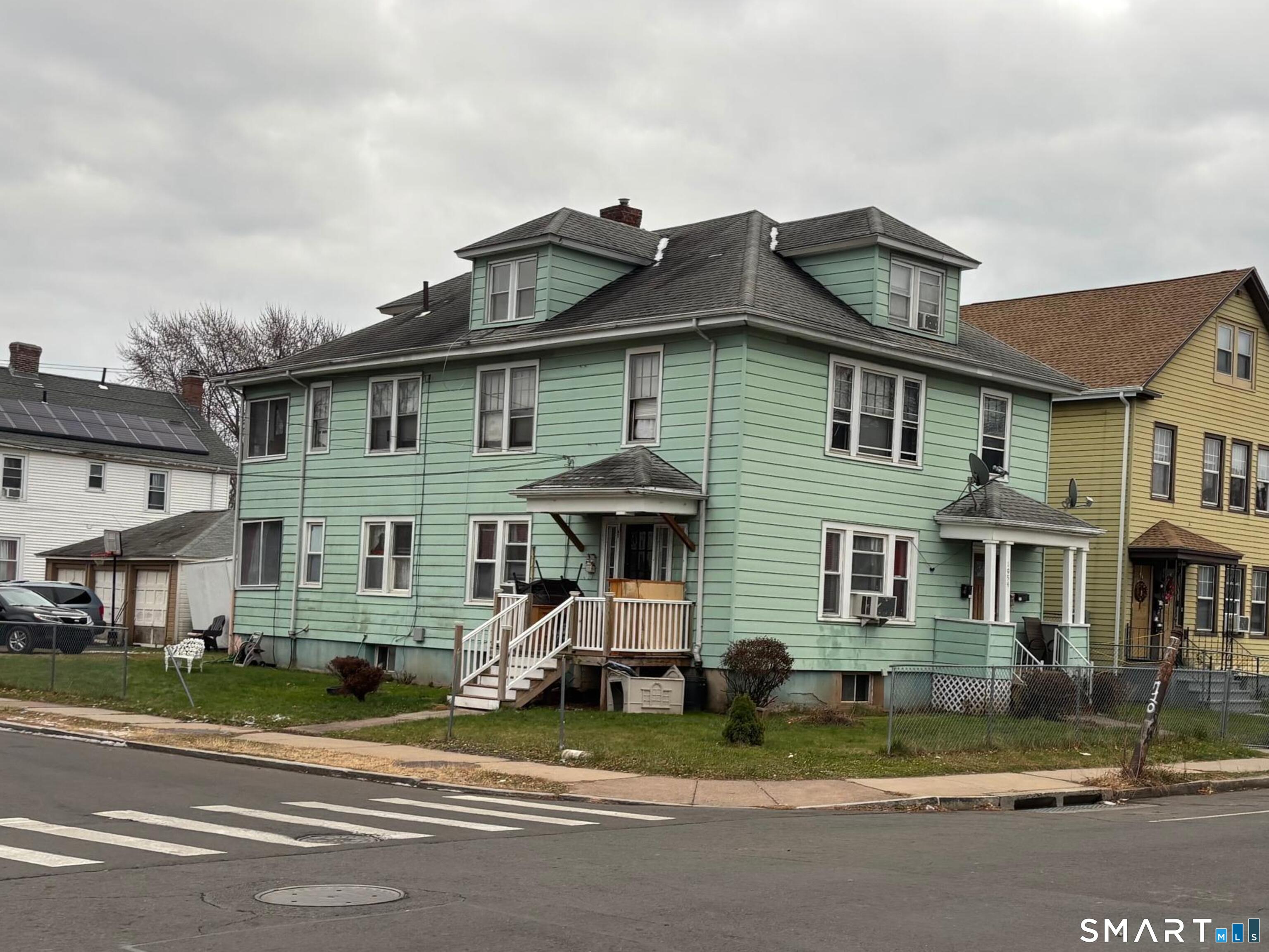 1954 Broad Street Hartford, CT 06114 - Photo 2 of 16 a view of a white house with large windows and a yard
