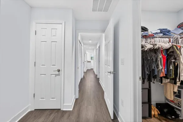 a view of a hallway with wooden floor and closet