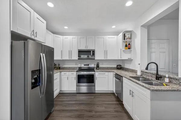 a kitchen with white cabinets stainless steel appliances and a sink