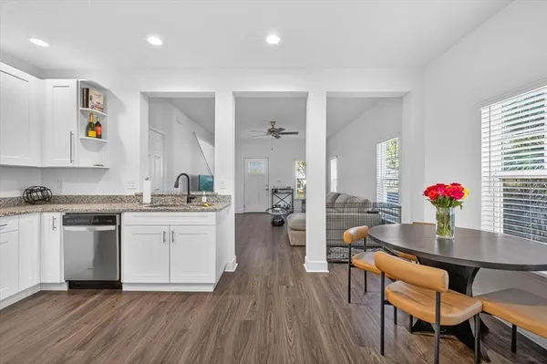 a kitchen with granite countertop white cabinets and white appliances