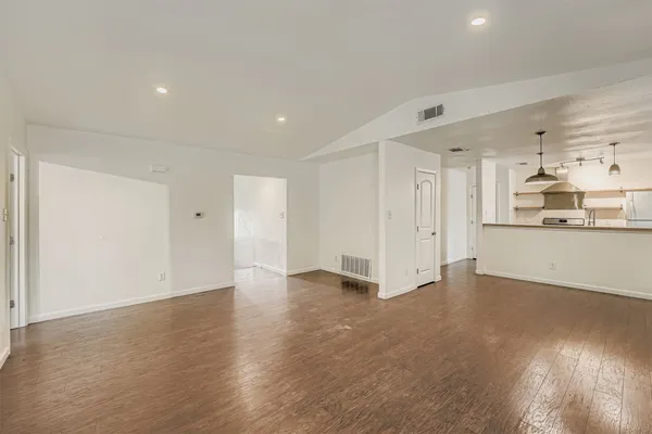 a view of an empty room with wooden floor