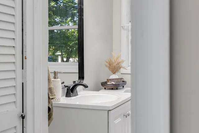 a bathroom with a sink a toilet and a window