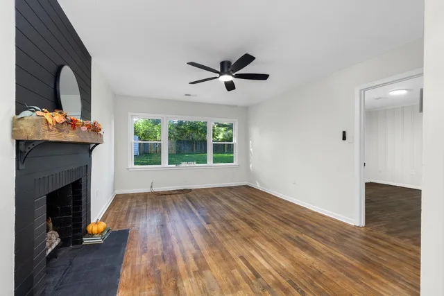 a view of a livingroom with wooden floor and a fireplace