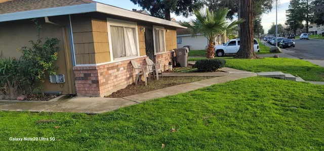 a view of a house with a yard and tree s