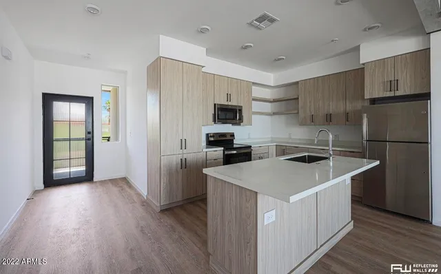 a kitchen that has a sink a refrigerator and a stove top oven