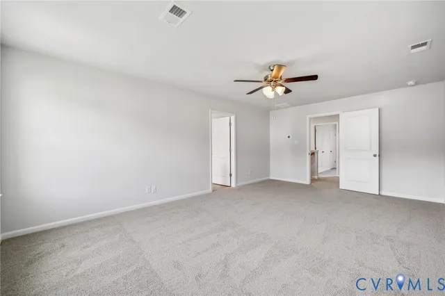 an empty room with closet and a ceiling fan