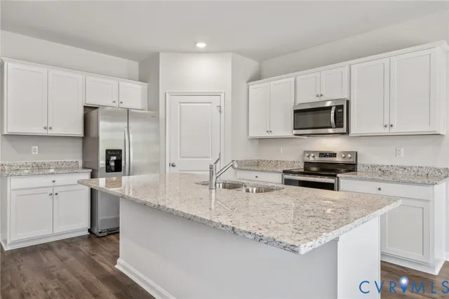 a kitchen with granite countertop a sink stove and refrigerator