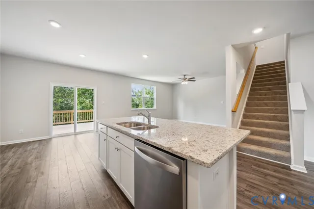 a kitchen with granite countertop a stove and a wooden floors