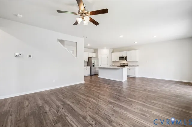 a view of kitchen with granite countertop cabinets and refrigerator