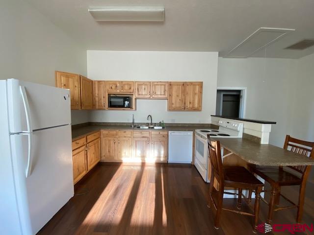 24194 Rd L Cortez, CO 81321 - Photo 23 of 30 a kitchen with granite countertop stainless steel appliances a refrigerator a stove a sink dishwasher a dining table and chairs with wooden floor