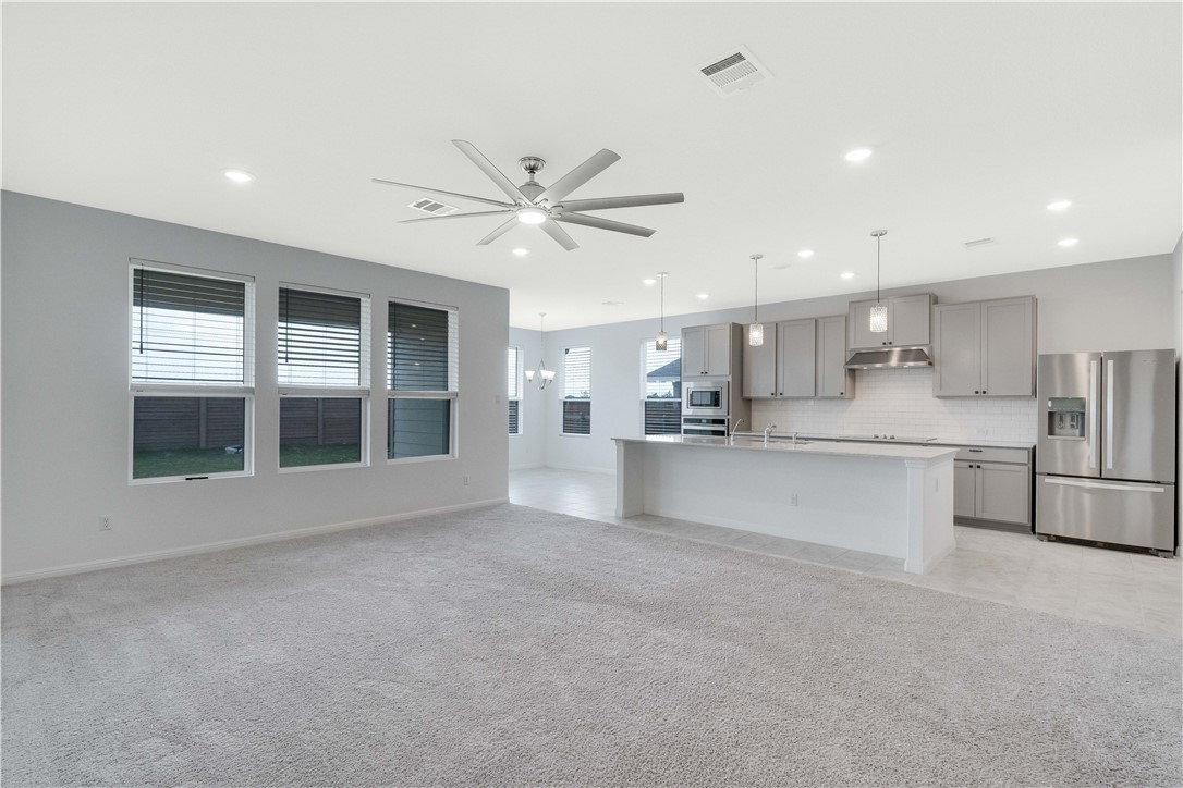 17629 Shafer Drive Pflugerville, TX 78660 - Photo 8 of 35 a view of large kitchen with stainless steel appliances kitchen island a large window and a counter top space