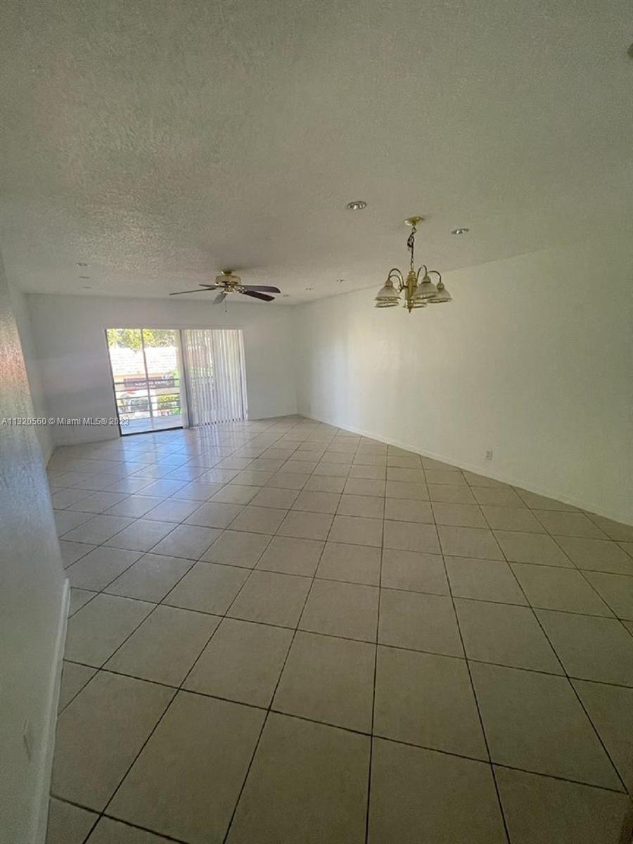 134 South Cypress Road, Unit 421 Pompano Beach, FL 33060 - Photo 5 of 12 en empty room with white walls and tiles
