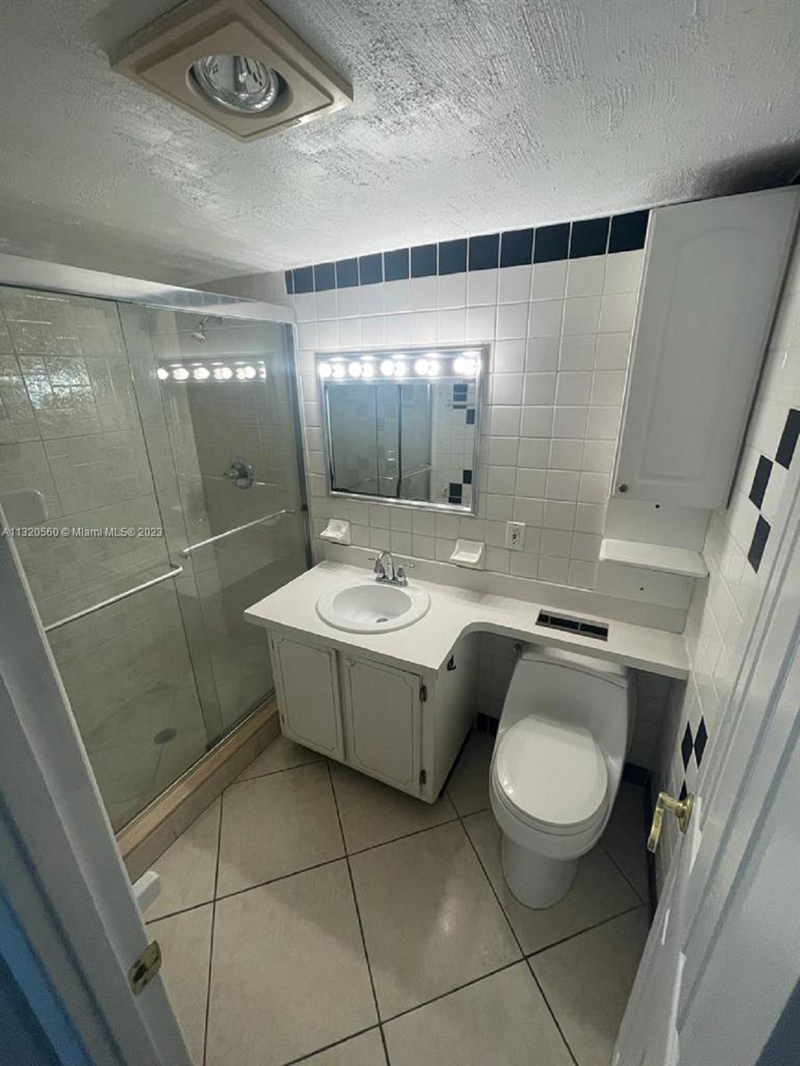 134 South Cypress Road, Unit 421 Pompano Beach, FL 33060 - Photo 7 of 12 a bathroom with a granite countertop sink mirror vanity and toilet