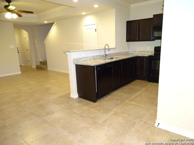 a kitchen with a sink and a stove top oven with wooden floor
