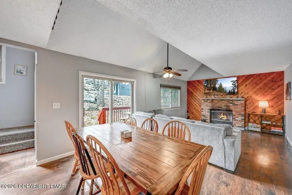 a view of a dining room with furniture a chandelier and wooden floor