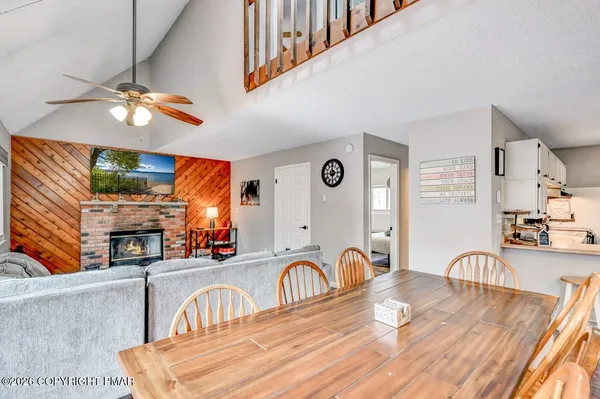 a kitchen with stainless steel appliances granite countertop a stove a sink dishwasher and a dining table with wooden floor