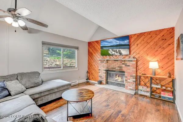 a living room with furniture a fireplace and a floor to ceiling window