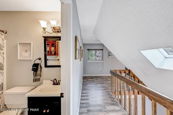 a view of a hallway with wooden floor and workspace