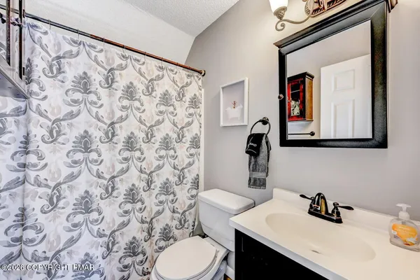 a bathroom with a sink a toilet and mirror