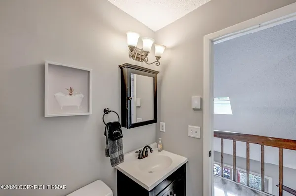 a bathroom with a sink a light fixture and a mirror