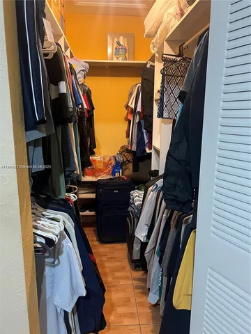 a view of walk in closet with clothes and shoes