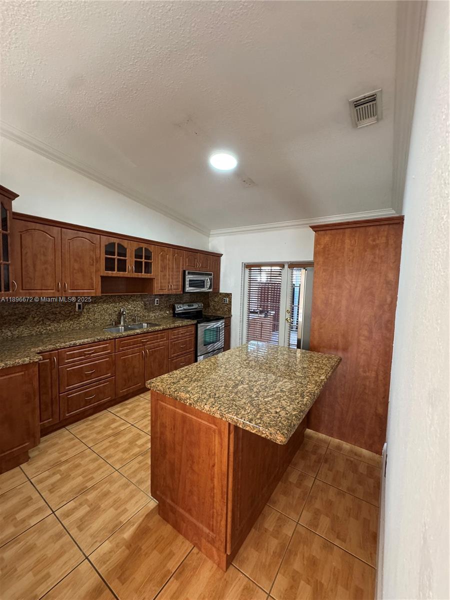 7667 Northwest 182nd Lane, Unit 805 Hialeah, FL 33015 - Photo 3 of 14 a kitchen with stainless steel appliances granite countertop a sink and counter space
