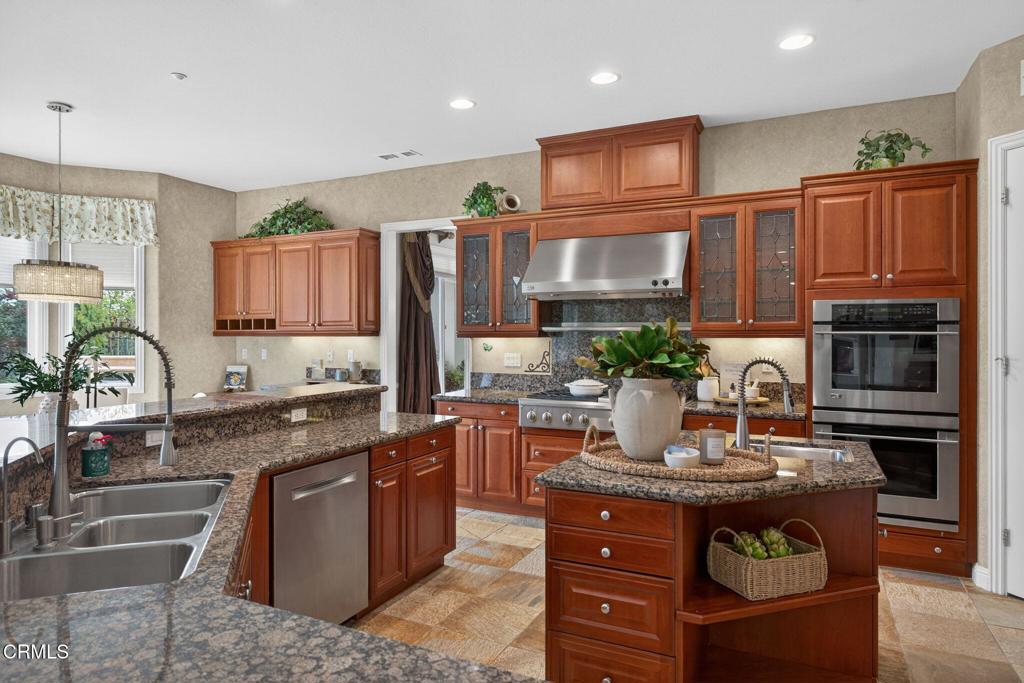 5352 Plata Rosa Court Camarillo, CA 93012 - Photo 25 of 75 a kitchen with stainless steel appliances granite countertop wooden cabinets a stove top oven a granite counter tops and a view of living room