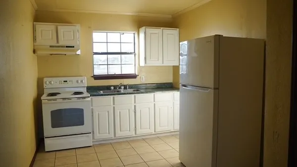 a kitchen with a refrigerator sink and cabinets