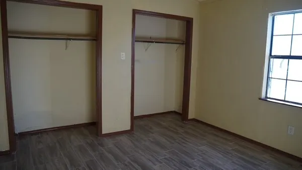an empty room with wooden floor and a window