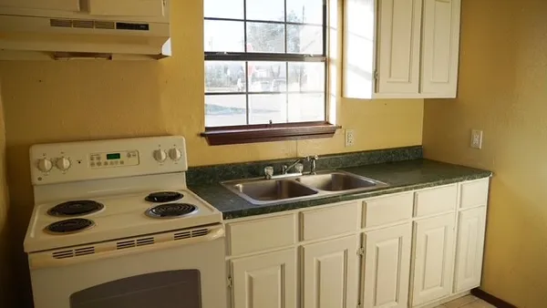a kitchen with a sink cabinets and a window
