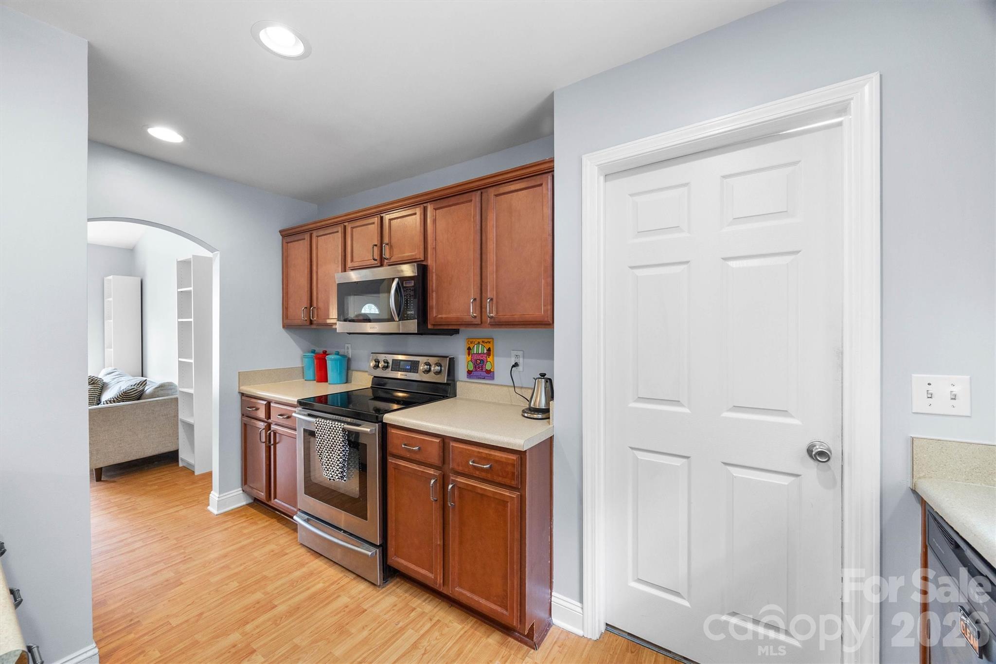 219 Nottingham Street York, SC 29745 - Photo 11 of 38 a kitchen with stainless steel appliances granite countertop a stove top oven a sink dishwasher and a refrigerator with wooden floor