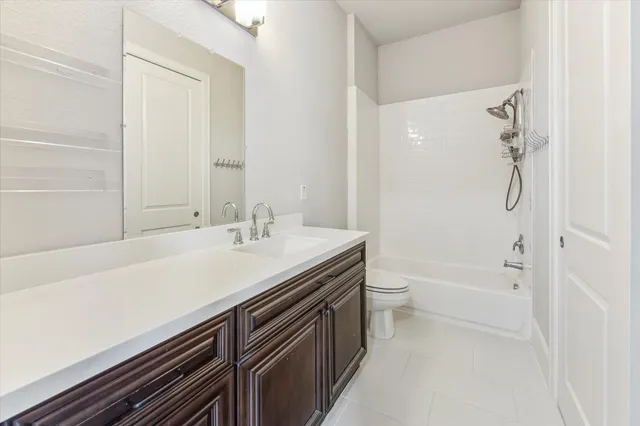 a bathroom with a granite countertop sink a toilet and shower