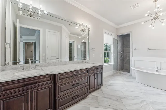 a bathroom with a granite countertop double vanity sink a mirror and a bathtub
