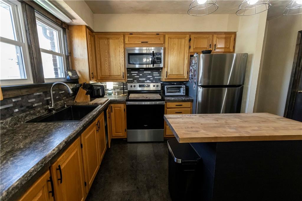 842 Anderson Street Confluence, PA 15424 - Photo 18 of 43 a kitchen with kitchen island granite countertop a refrigerator stove and sink