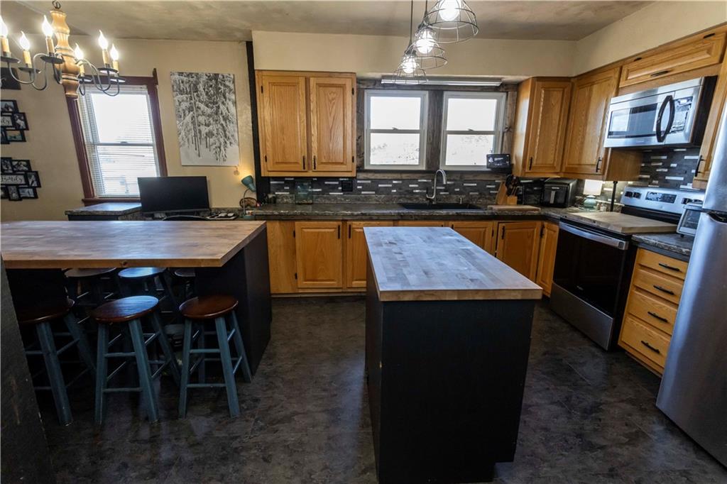 842 Anderson Street Confluence, PA 15424 - Photo 19 of 43 a kitchen with a stove a sink a microwave a dining table and chairs