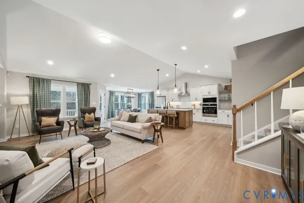 a living room with furniture and a dining table with wooden floor