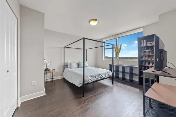 a bedroom with a bed and lamp with the wooden floor