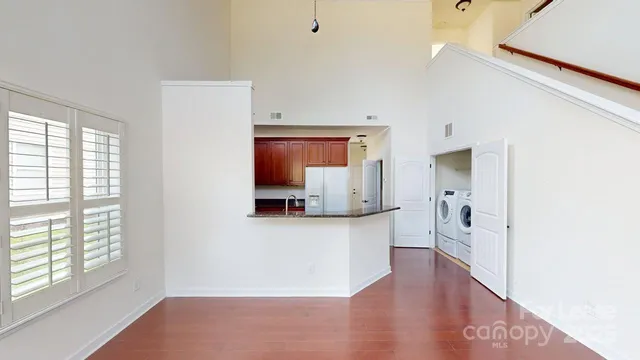 a view of a kitchen with wooden floor and a window