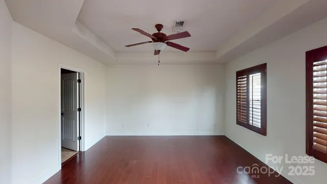 a view of a hallway with windows and chandelier fan