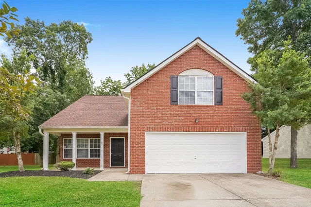 a front view of a house with a yard and garage