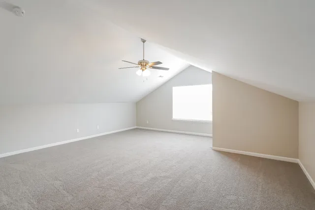 an empty room with wooden floor and ceiling fan