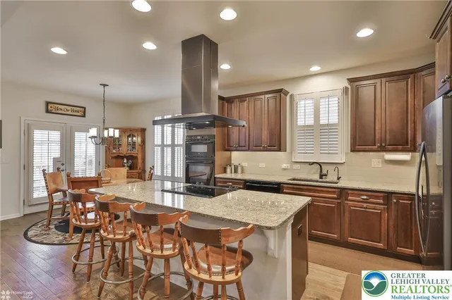 a kitchen with a stove a refrigerator and a dining table with wooden floor