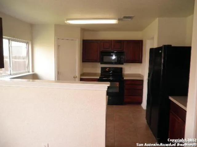 a kitchen with a refrigerator and a stove top oven