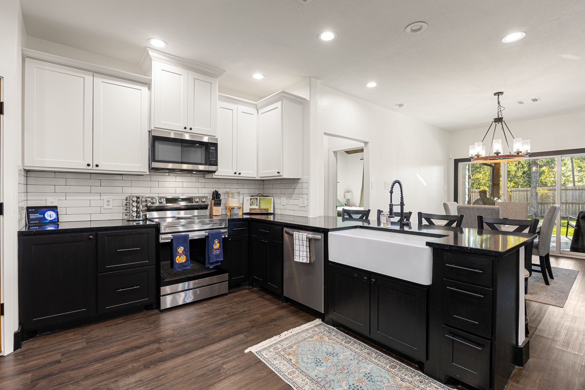 24571 Armagh Road Hempstead, TX 77445 - Photo 12 of 45 a kitchen with stainless steel appliances granite countertop a stove top oven a sink dishwasher a dining table and chairs with wooden floor