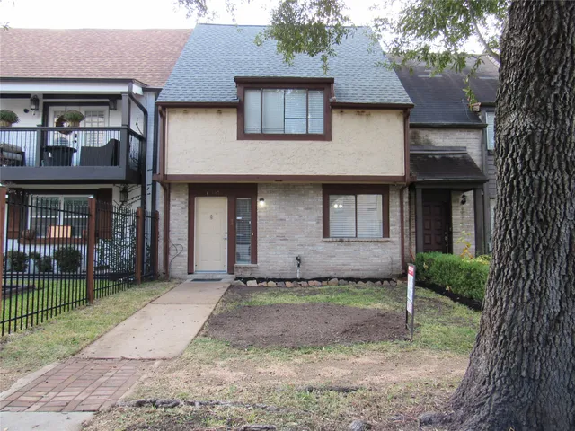 a view of an empty room with wooden floor and a fan