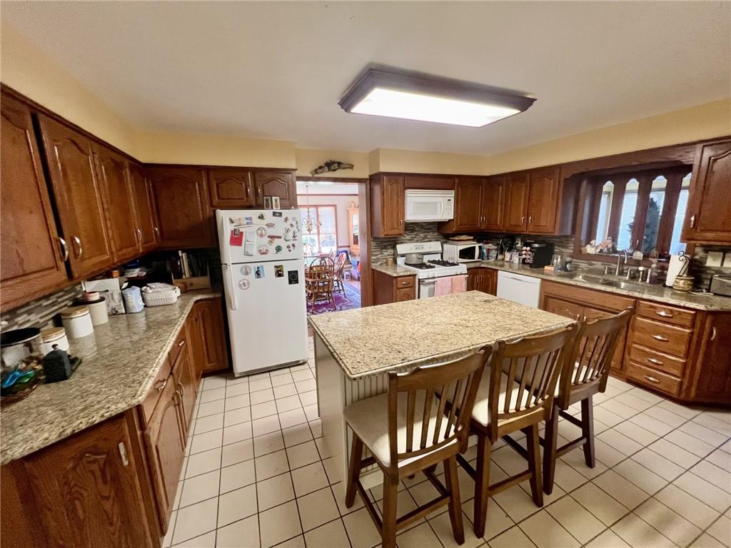 280 Derrick Avenue Uniontown, PA 15401 - Photo 12 of 28 a kitchen with granite countertop a stove a sink a oven a dining table and chairs