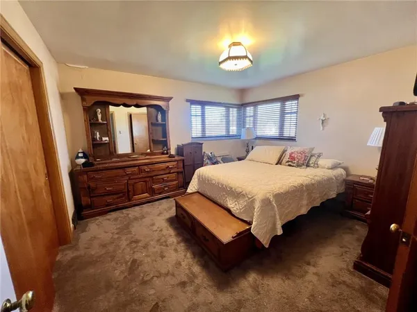 a bedroom with a bed and dresser with mirror